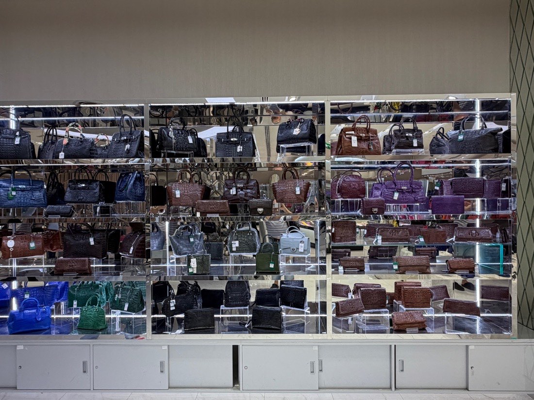 Lit wall cabinets filled with crocodile leather handbags